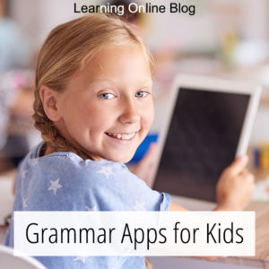 Smiling girl holding tablet - Grammar Apps for Kids