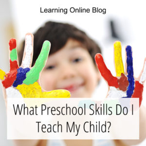 Boy holding up painted hands - What Preschool Skills Do I Teach My Child?